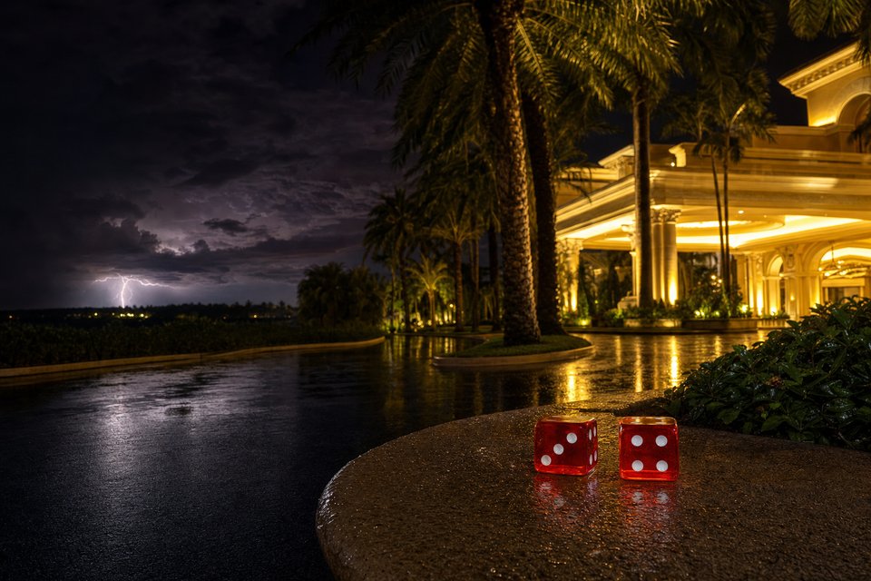 A palm-lined casino resort entrance on a humid Florida night, with lightning flickering over the horizon (AI-generated image)